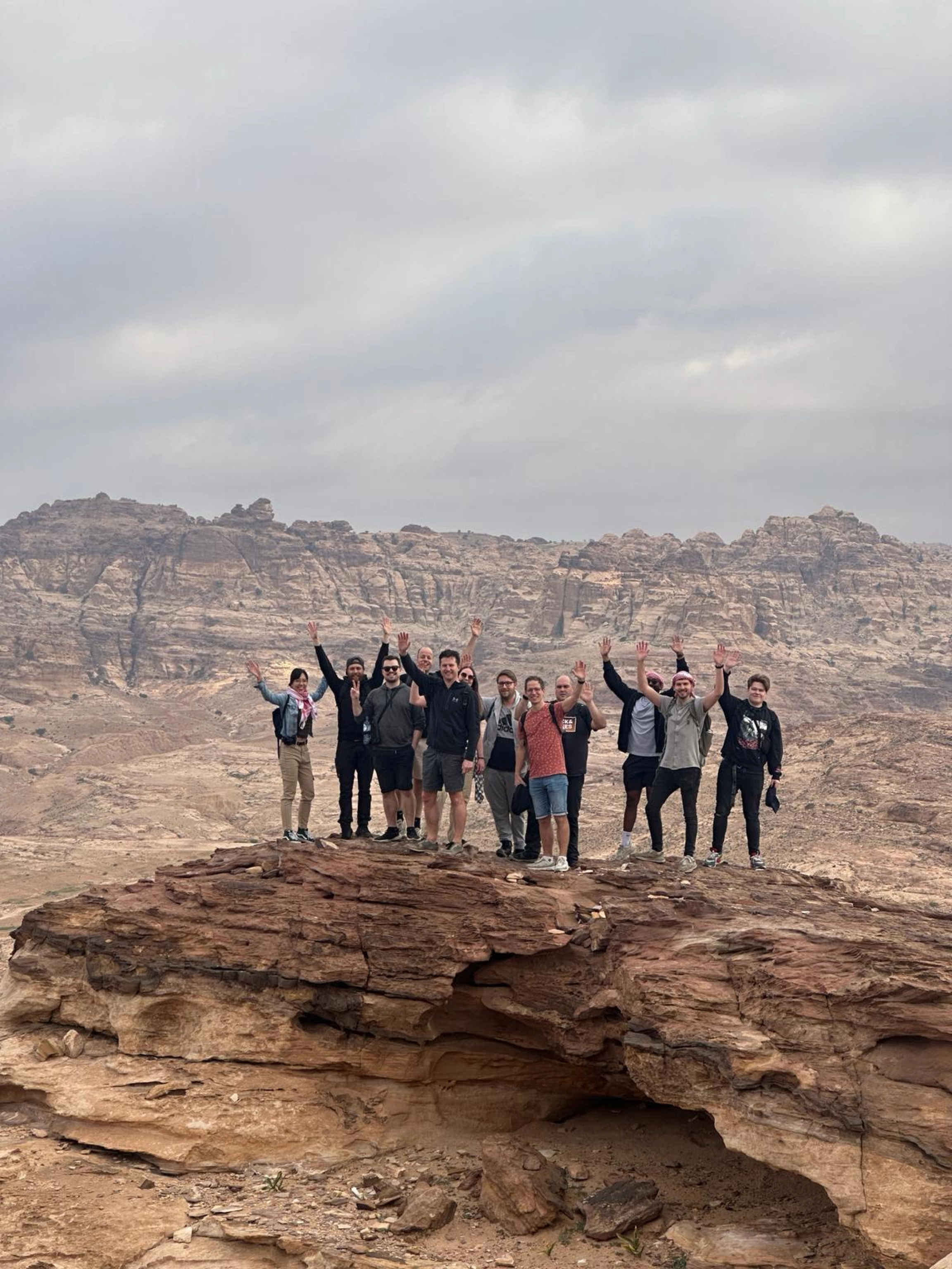 Groepsfoto van development - Samen met de handen in de lucht in een woestijnomgeving