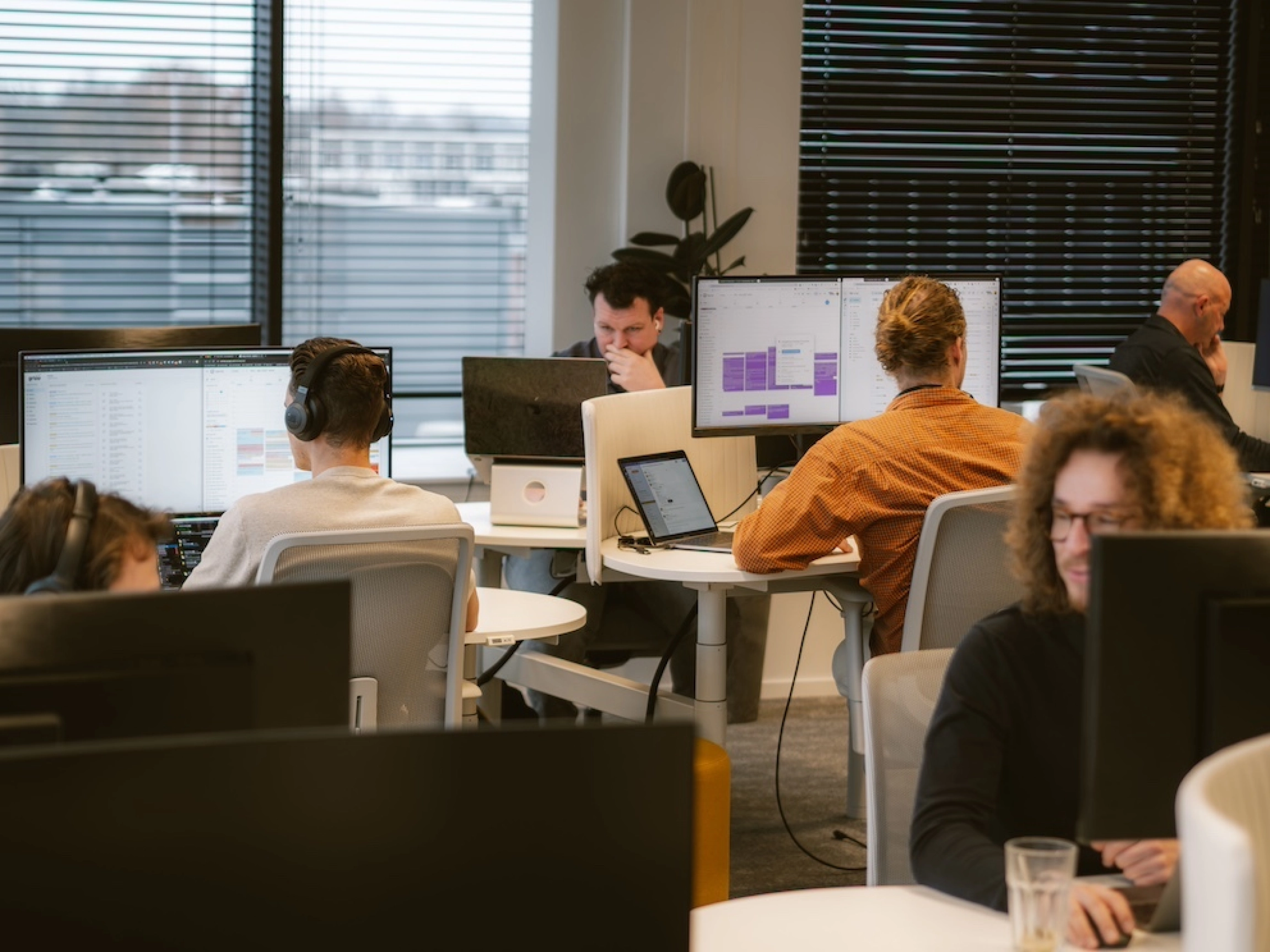 Werknemers van Happy Horizon op kantoor aan het werk achter bureau's