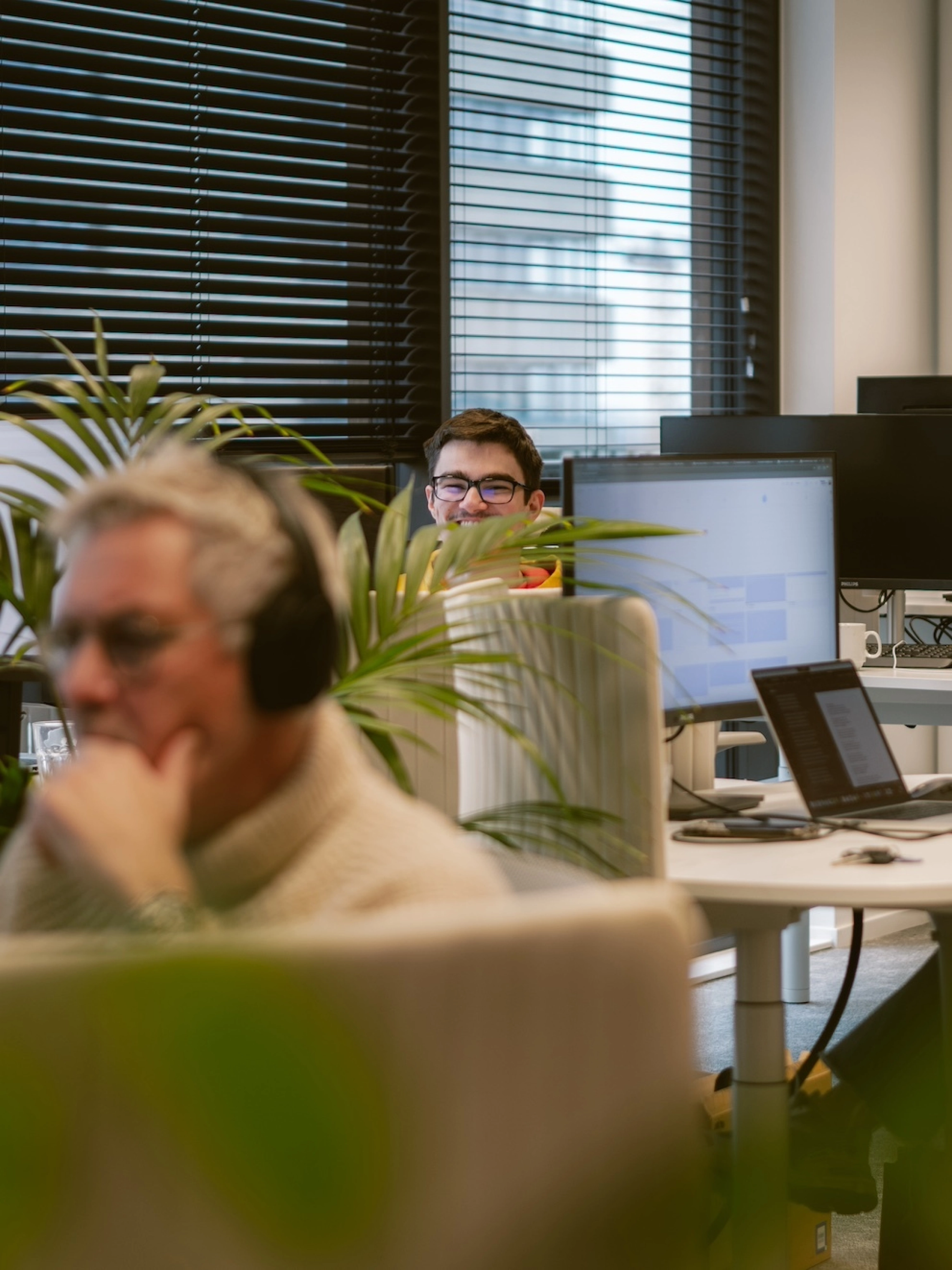 Werknemers van Happy Horizon achter bureau's op kantoor